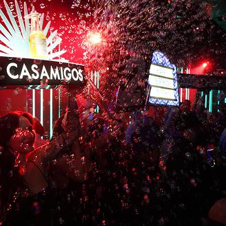 "A nightclub with people celebrating under bubbles, a sign reading 